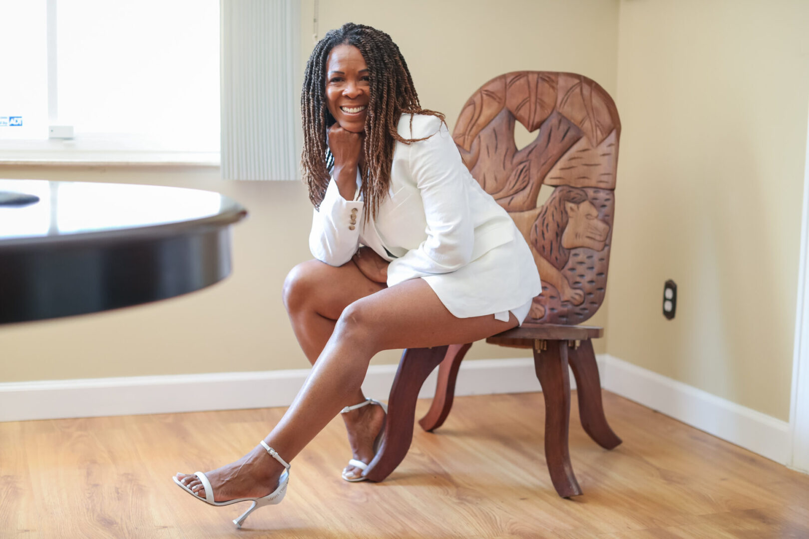 A woman sitting on top of a wooden chair.