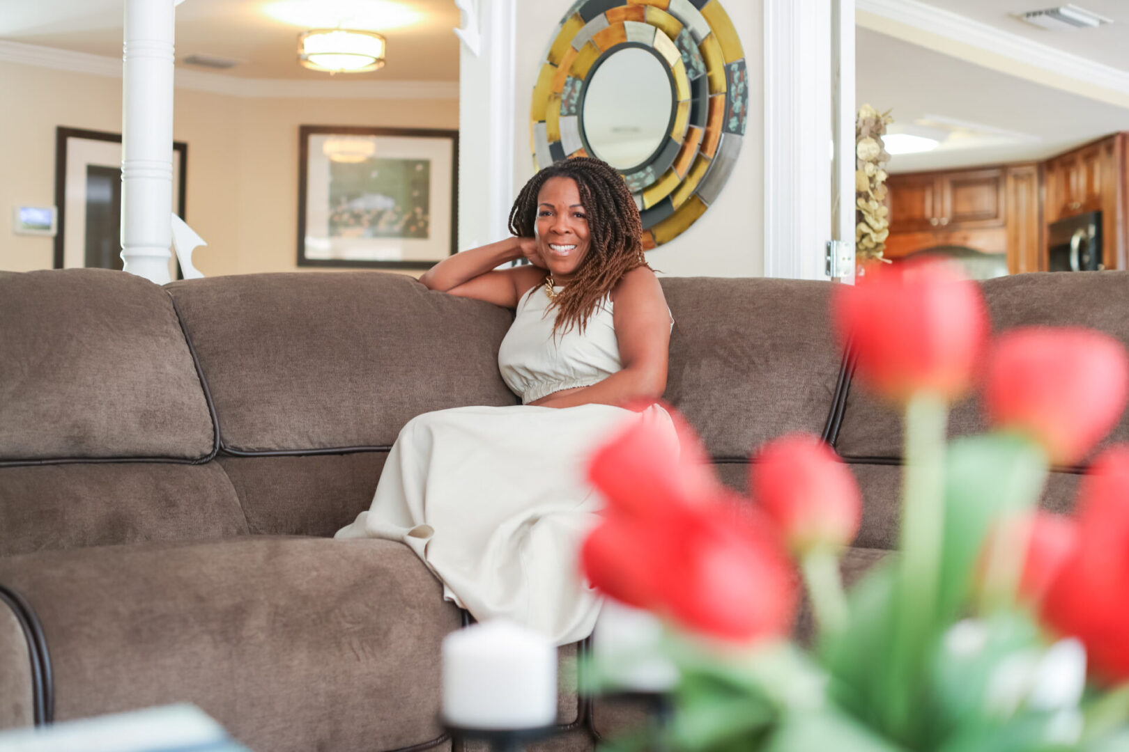 A woman sitting on top of a brown couch.